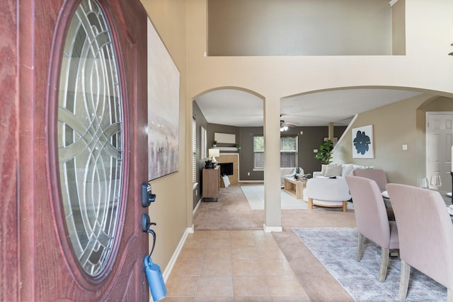28210 Slatestone Ln, Spring, TX 77386 - entrance foyer featuring arched walkways, a ceiling fan, light tile patterned floors, and light colored carpet