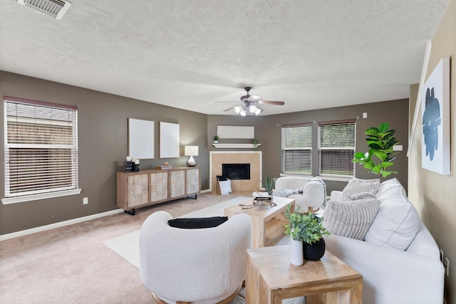 28210 Slatestone Ln, Spring, TX 77386 - carpeted living room with ceiling fan, a tile fireplace, and a textured ceiling