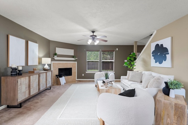 28210 Slatestone Ln, Spring, TX 77386 - living room with light carpet, a tiled fireplace, ceiling fan, and a textured ceiling