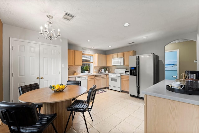 28210 Slatestone Ln, Spring, TX 77386 - kitchen featuring white appliances, light brown cabinetry, arched walkways, a chandelier, and backsplash