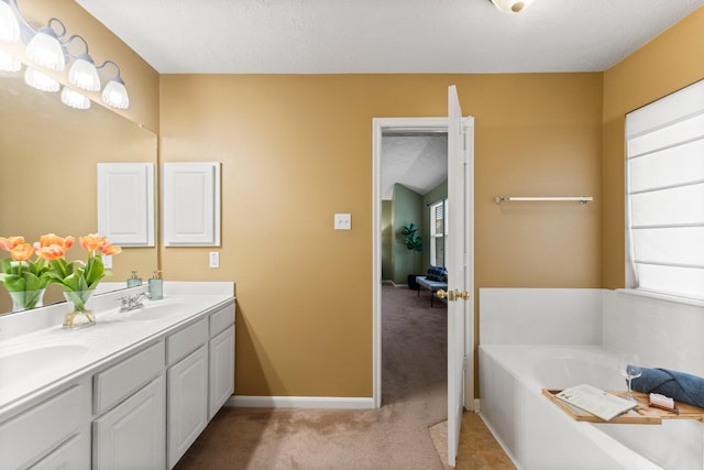 28210 Slatestone Ln, Spring, TX 77386 - bathroom featuring double vanity, a garden tub, and a textured ceiling