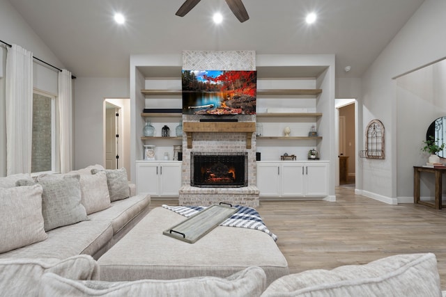 206 Rim Rock Rd, Huntsville, TX 77340 - living room with light wood-style floors, ceiling fan, a brick fireplace, vaulted ceiling, and recessed lighting