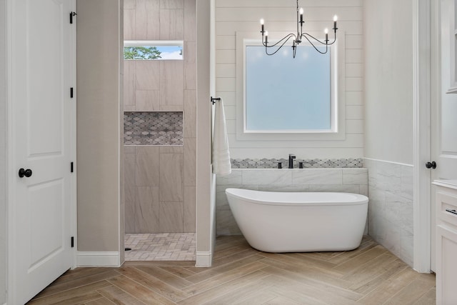 206 Rim Rock Rd, Huntsville, TX 77340 - bathroom featuring a freestanding tub, a chandelier, a walk in shower, tile walls, and wood finished floors