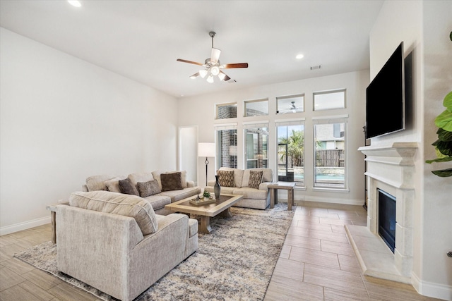 2314 Umber Oaks Ln, Fulshear, TX 77423 - living area with a glass covered fireplace, a ceiling fan, recessed lighting, and wood finish floors