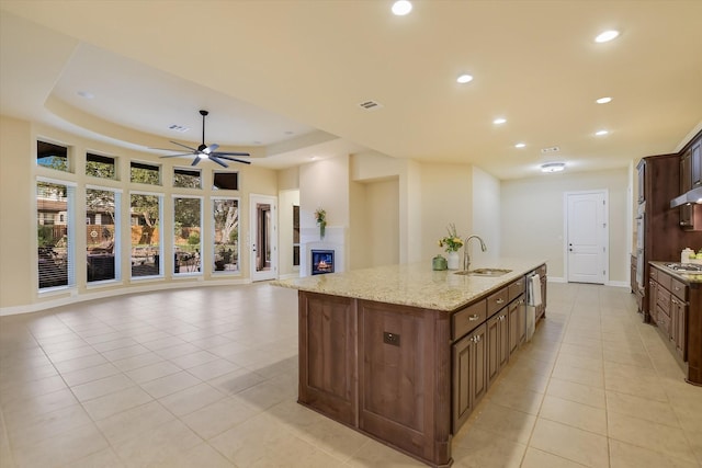 2728 Long Lasso Pass, Leander, TX 78641 - kitchen featuring light tile patterned floors, a kitchen island with sink, recessed lighting, ceiling fan, and light stone countertops