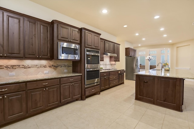 2728 Long Lasso Pass, Leander, TX 78641 - kitchen with appliances with stainless steel finishes, dark brown cabinetry, tasteful backsplash, recessed lighting, and light tile patterned floors