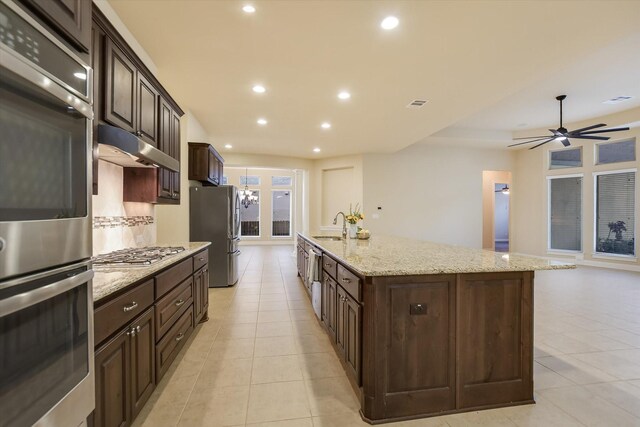 2728 Long Lasso Pass, Leander, TX 78641 - kitchen with appliances with stainless steel finishes, under cabinet range hood, a spacious island, light tile patterned flooring, and recessed lighting