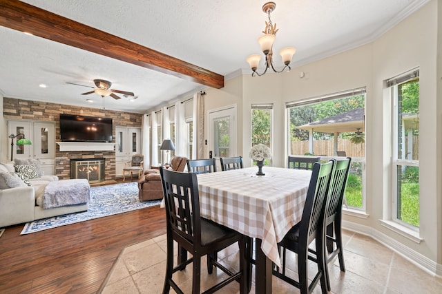 16447 Flint Run Way, Sugar Land, TX 77498 - dining space featuring beam ceiling, a fireplace, a textured ceiling, a chandelier, and a ceiling fan