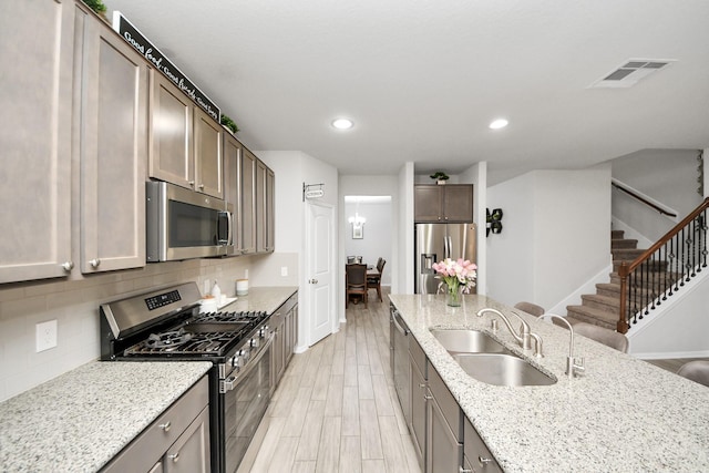 5206 Wyatt James Ln, Brookshire, TX 77423 - kitchen with appliances with stainless steel finishes, backsplash, light stone countertops, light wood-type flooring, and recessed lighting