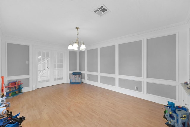 7403 Theisswood Rd, Spring, TX 77379 - rec room with wood finished floors, a chandelier, ornamental molding, and a decorative wall