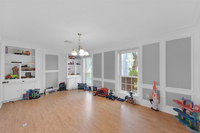7403 Theisswood Rd, Spring, TX 77379 - playroom with built in shelves, wood finished floors, a chandelier, and ornamental molding