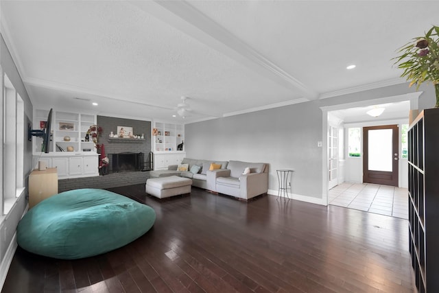 7403 Theisswood Rd, Spring, TX 77379 - living room featuring wood finished floors, ornamental molding, a ceiling fan, a textured ceiling, and a brick fireplace