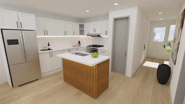 1316 W Willis St, Alvin, TX 77511 - kitchen featuring appliances with stainless steel finishes, under cabinet range hood, light wood finished floors, light countertops, and decorative backsplash