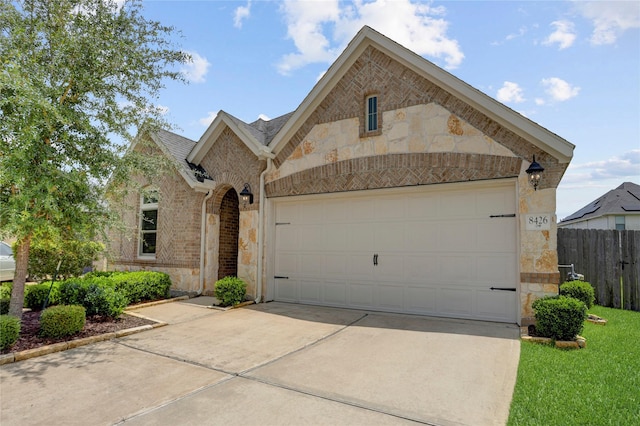 8426 Kari Bend Cir, Richmond, TX 77407 - french provincial home featuring stone siding, driveway, an attached garage, and brick siding