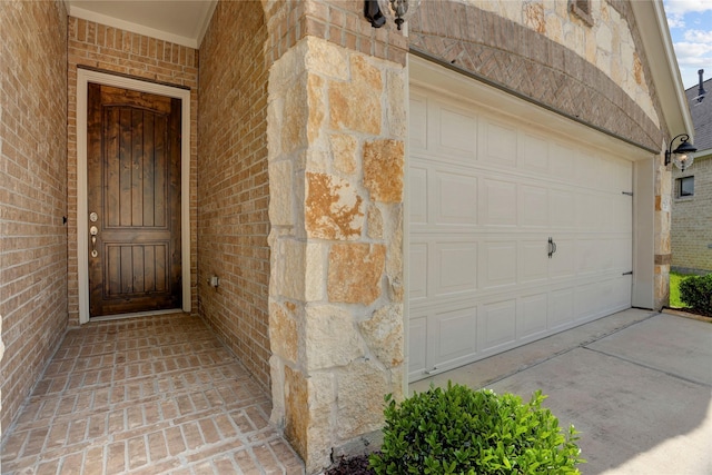 8426 Kari Bend Cir, Richmond, TX 77407 - view of exterior entry featuring brick siding, a garage, and stone siding
