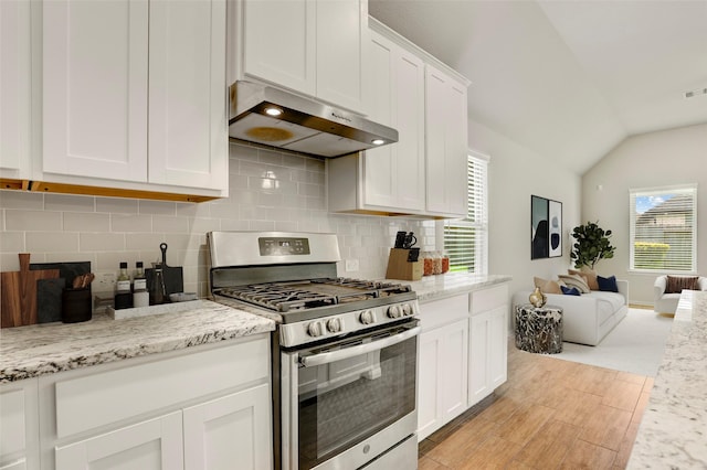8426 Kari Bend Cir, Richmond, TX 77407 - kitchen featuring gas range, exhaust hood, open floor plan, light wood-style floors, and white cabinetry