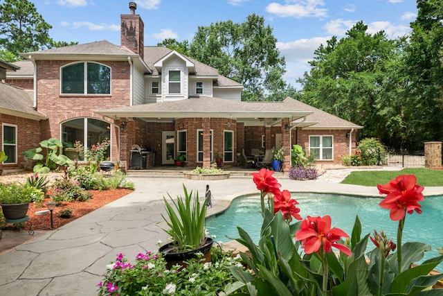 10530 Clubhouse Cir, Magnolia, TX 77354 - back of property with a chimney, a shingled roof, a patio, and brick siding