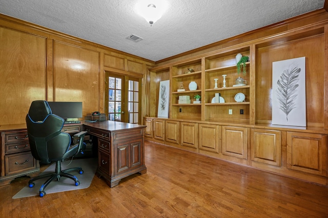 10530 Clubhouse Cir, Magnolia, TX 77354 - home office with ornamental molding, light wood-style flooring, wooden walls, a textured ceiling, and french doors