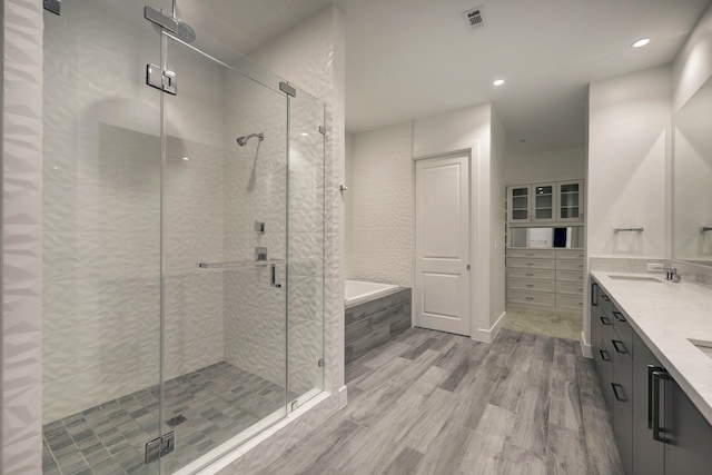 4521 San Felipe St Unit 2304-5, Houston, TX 77027 - full bath with a garden tub, wood finished floors, double vanity, a shower stall, and recessed lighting