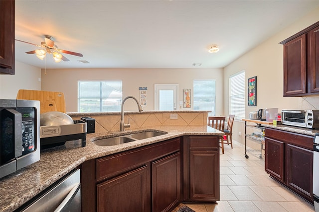 19914 Pemetic Trl, Richmond, TX 77407 - kitchen with stainless steel appliances, healthy amount of natural light, light tile patterned flooring, and ceiling fan
