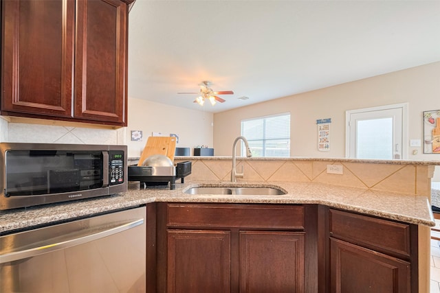19914 Pemetic Trl, Richmond, TX 77407 - kitchen with stainless steel appliances, a ceiling fan, backsplash, light stone countertops, and a peninsula