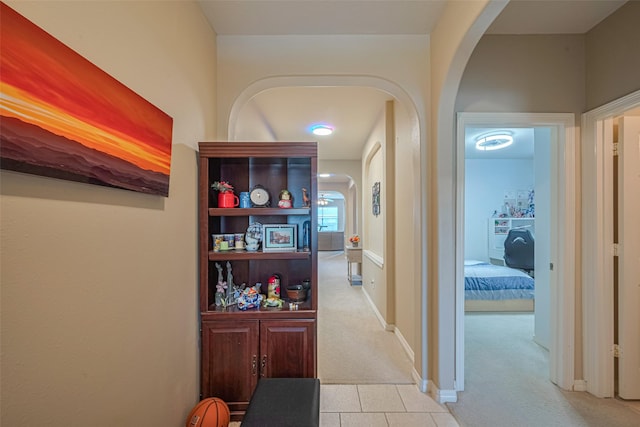 19914 Pemetic Trl, Richmond, TX 77407 - hallway featuring arched walkways, light carpet, and light tile patterned flooring