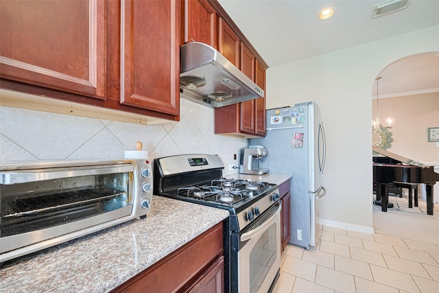 19914 Pemetic Trl, Richmond, TX 77407 - kitchen featuring stainless steel appliances, extractor fan, arched walkways, tasteful backsplash, and recessed lighting
