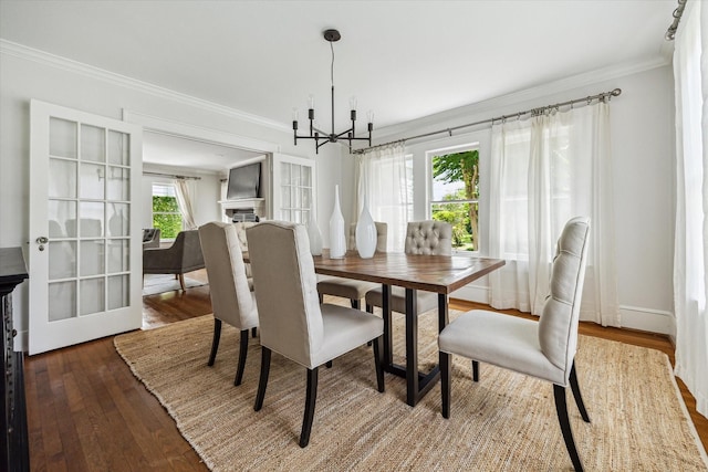 1656 Norfolk St, Houston, TX 77006 - dining room featuring a chandelier, crown molding, and wood finished floors