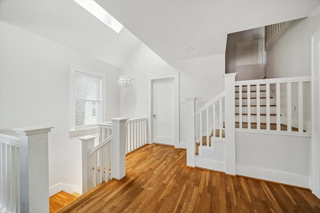 1656 Norfolk St, Houston, TX 77006 - hallway with an upstairs landing, wood finished floors, vaulted ceiling, and a skylight