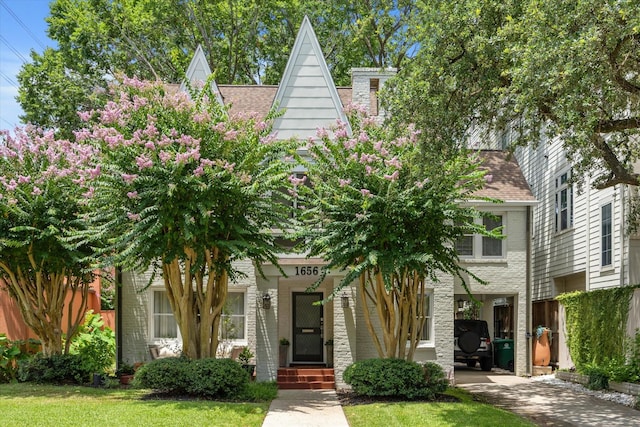1656 Norfolk St, Houston, TX 77006 - view of front of home with a front yard, brick siding, roof with shingles, and driveway