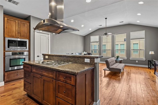 112 Riley Ln, Houston, TX 77003 - kitchen featuring island range hood, appliances with stainless steel finishes, light wood finished floors, vaulted ceiling, and open floor plan