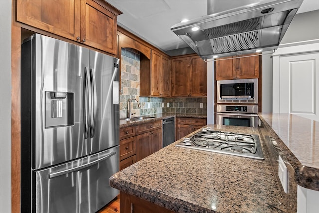 112 Riley Ln, Houston, TX 77003 - kitchen featuring appliances with stainless steel finishes, extractor fan, brown cabinets, and dark stone counters