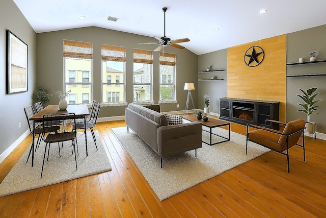 112 Riley Ln, Houston, TX 77003 - living area featuring vaulted ceiling, a warm lit fireplace, light wood-style flooring, ceiling fan, and recessed lighting