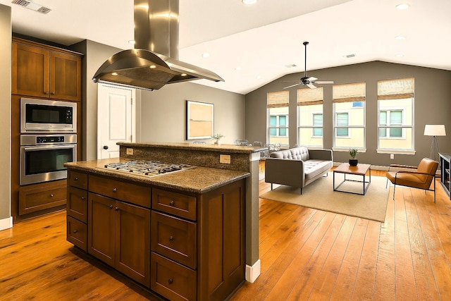 112 Riley Ln, Houston, TX 77003 - kitchen with appliances with stainless steel finishes, island range hood, open floor plan, a ceiling fan, and hardwood / wood-style floors