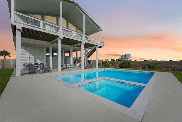 3430 Indian Beach Dr, Galveston, TX 77554 - back of property at dusk featuring a patio, an in-ground hot tub, and a fenced backyard
