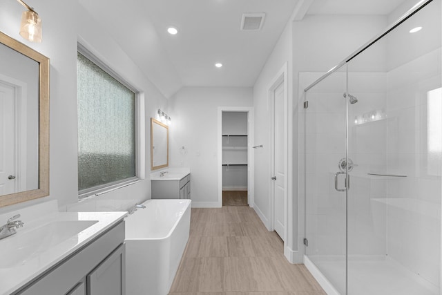21410 Flora Springs Ln, Magnolia, TX 77355 - bathroom with a stall shower, two vanities, a freestanding bath, recessed lighting, and a spacious closet