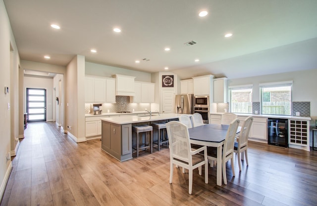 20207 Noble Arabian Dr, Tomball, TX 77377 - dining space featuring beverage cooler, light wood finished floors, and recessed lighting