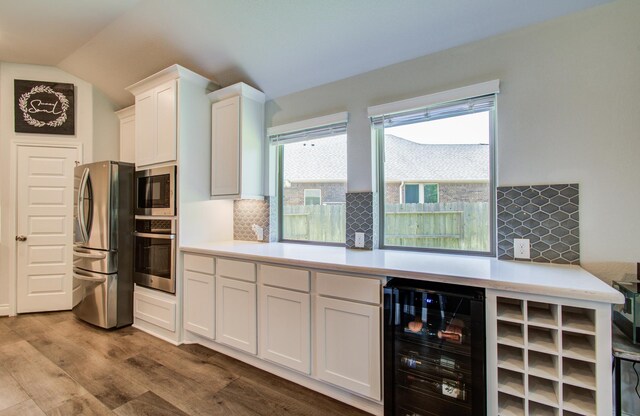 20207 Noble Arabian Dr, Tomball, TX 77377 - kitchen with appliances with stainless steel finishes, wine cooler, white cabinetry, light countertops, and tasteful backsplash