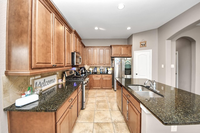 6810 Hunters Trace Ln, Baytown, TX 77521 - kitchen featuring stainless steel appliances, arched walkways, backsplash, brown cabinets, and recessed lighting