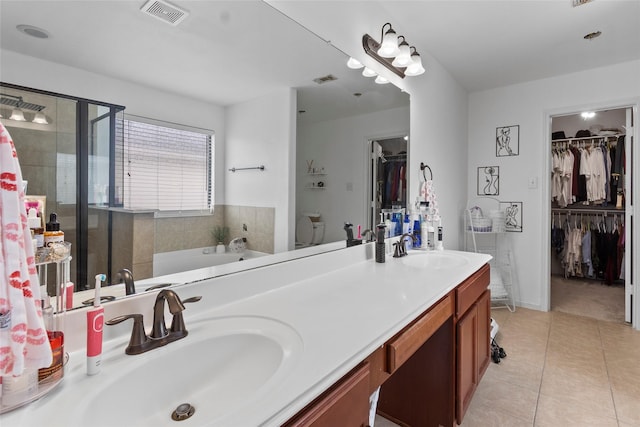 13206 Blass Ct, Houston, TX 77044 - bathroom featuring a spacious closet, double vanity, a garden tub, a stall shower, and tile patterned flooring