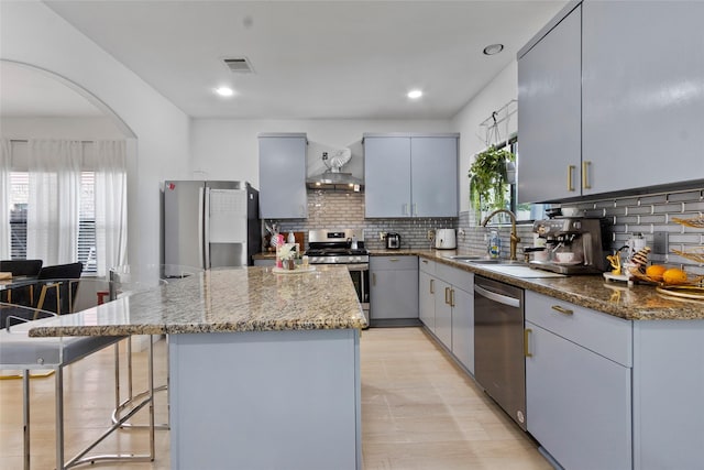 13206 Blass Ct, Houston, TX 77044 - kitchen with stainless steel appliances, a center island, backsplash, light stone counters, and arched walkways