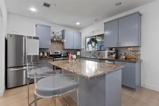13206 Blass Ct, Houston, TX 77044 - kitchen with stainless steel appliances, backsplash, dark stone counters, gray cabinets, and a center island