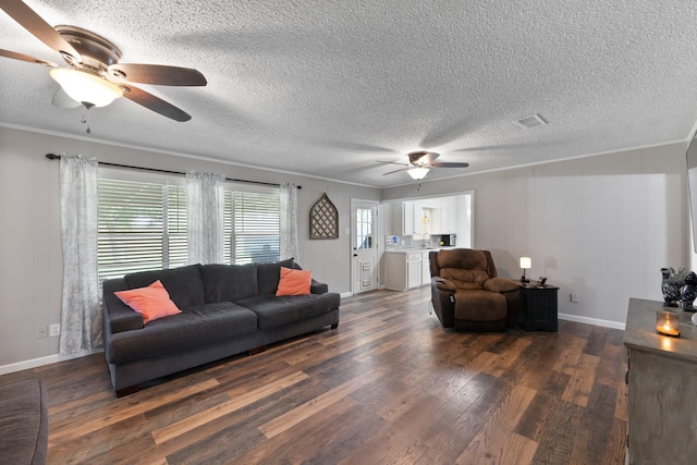 2605 Perry Ln, Alvin, TX 77511 - living room featuring a ceiling fan, dark wood-style flooring, crown molding, and a textured ceiling