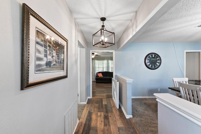 2605 Perry Ln, Alvin, TX 77511 - hallway featuring a chandelier, a textured ceiling, and dark wood-style floors
