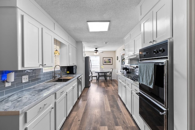 2605 Perry Ln, Alvin, TX 77511 - kitchen featuring stainless steel appliances, a textured ceiling, tasteful backsplash, white cabinets, and dark wood-style flooring
