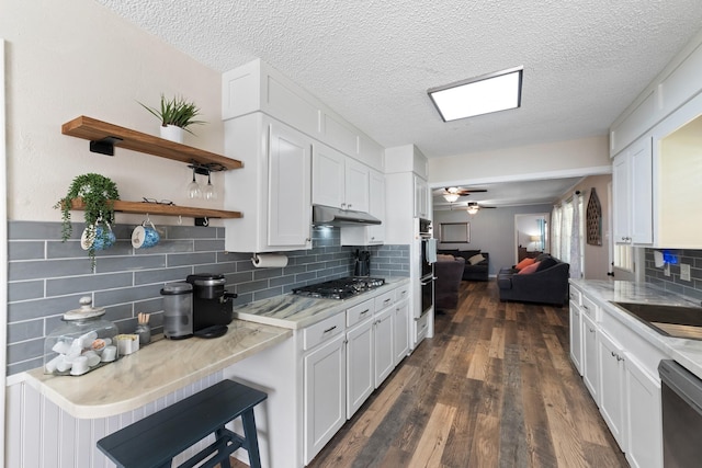 2605 Perry Ln, Alvin, TX 77511 - kitchen featuring appliances with stainless steel finishes, open floor plan, white cabinets, backsplash, and a textured ceiling