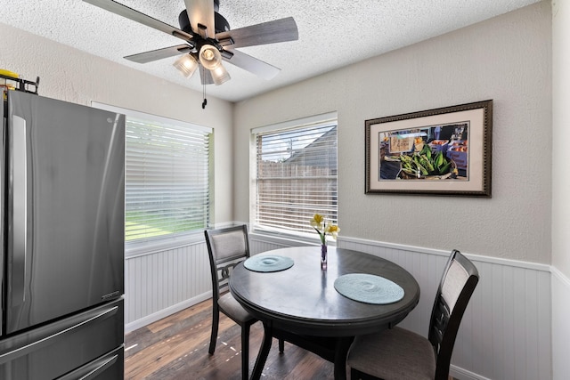 2605 Perry Ln, Alvin, TX 77511 - dining space featuring wood finished floors, a wainscoted wall, a textured ceiling, a ceiling fan, and a textured wall