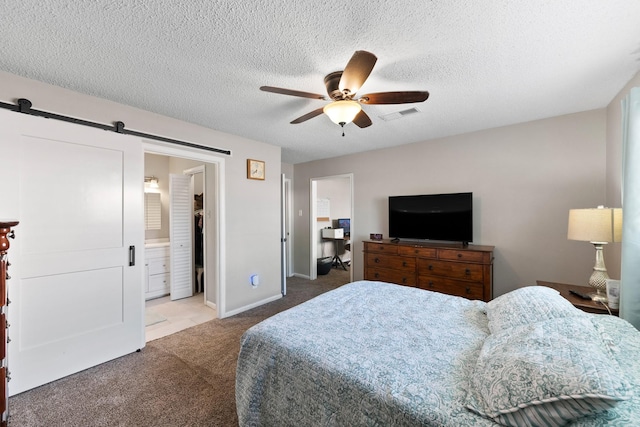 2605 Perry Ln, Alvin, TX 77511 - bedroom with carpet flooring, a barn door, a ceiling fan, a textured ceiling, and connected bathroom