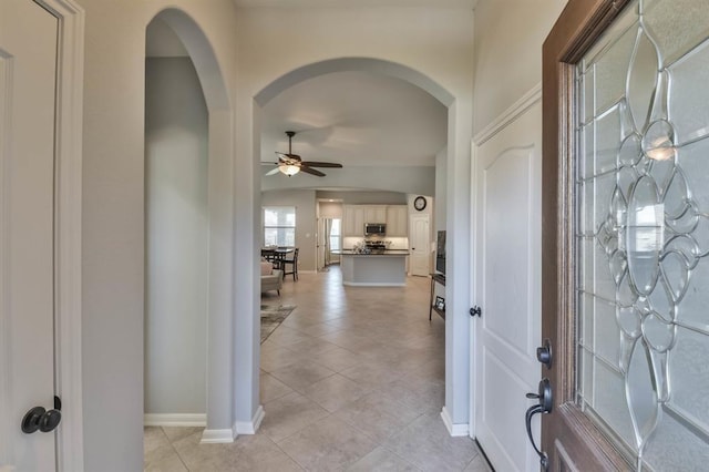 8922 Pinenut Dr, Cypress, TX 77433 - foyer featuring ceiling fan, arched walkways, and light tile patterned floors