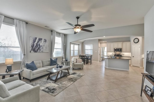 8922 Pinenut Dr, Cypress, TX 77433 - living room with light tile patterned floors, a ceiling fan, and arched walkways